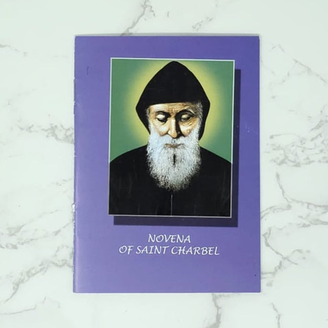 Novena Booklet in english with a portrait of Saint Charbel on it, on a marble surface
