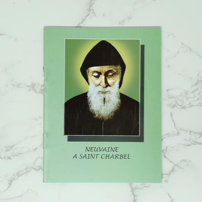 Novena Booklet in French with a portrait of Saint Charbel on it, on a marble surface