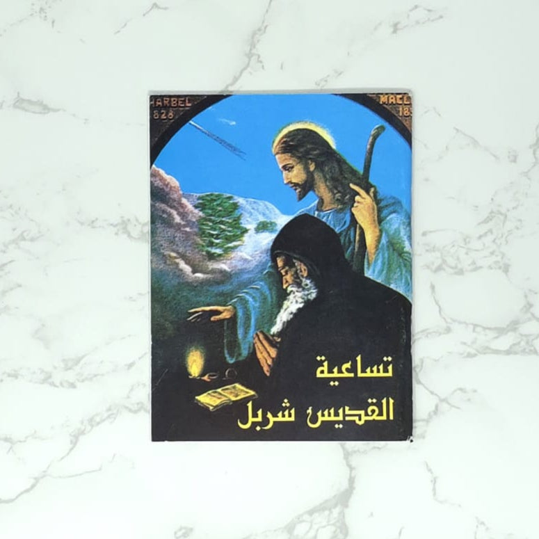 Novena of Saint Charbel in arabic  Book cover with artistic depiction of a figure and landscape on a marble background
