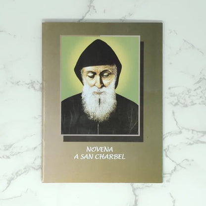 Novena Booklet in Spanish with a portrait of Saint Charbel on it, on a marble surface